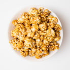 Sweet caramel peanut popcorn in a clear bag from Colorado Popcorn Company, showcasing golden caramel coating and crunchy peanuts.