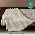 Cream white CozyNest Decor faux fur throw blanket on a couch, thick and fluffy for cozy living room decor and gifting.