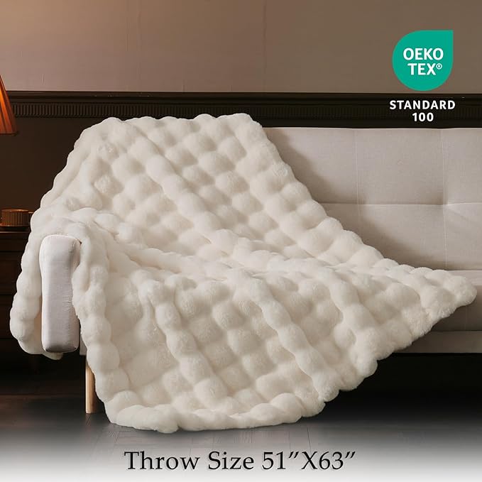 Cream white CozyNest Decor faux fur throw blanket on a couch, thick and fluffy for cozy living room decor and gifting.