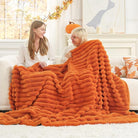 CozyNest Decor Cozy Bliss Fall Harvest faux fur throw blanket in burnt orange, plush striped design on a sofa for warm decor.