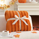 CozyNest Decor fall harvest faux fur throw blanket in burnt orange, plush striped design on a sofa for cozy home decor.