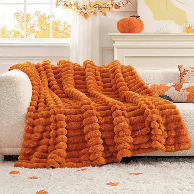 CozyNest Decor fall harvest faux fur throw blanket in burnt orange, plush striped design on a sofa for cozy home decor.