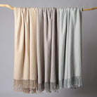 CozyNest Decor Cuddle Dreams silk throw blanket in taupe with hand-knotted fringe, soft, breathable herringbone design.