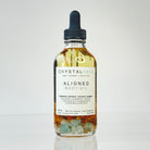 Crystal Irie Aligned Body Oil bottle showing a sleek glass container with a golden cap and a minimalistic label, full view.