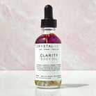 Crystal Irie Clarity Body Oil bottle with the oil's clear, smooth texture and elegant packaging visible in the image.