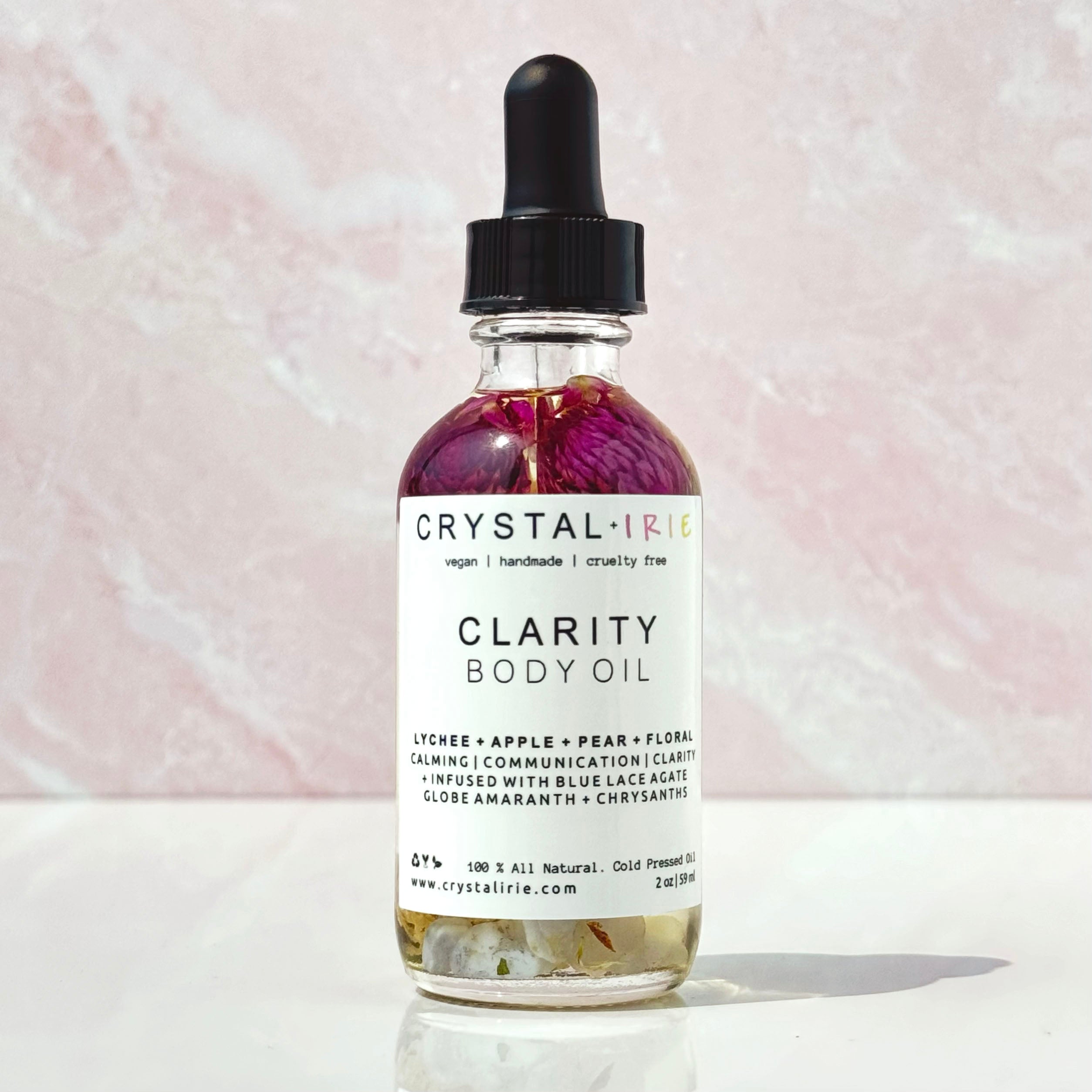 Crystal Irie Clarity Body Oil bottle with the oil's clear, smooth texture and elegant packaging visible in the image.