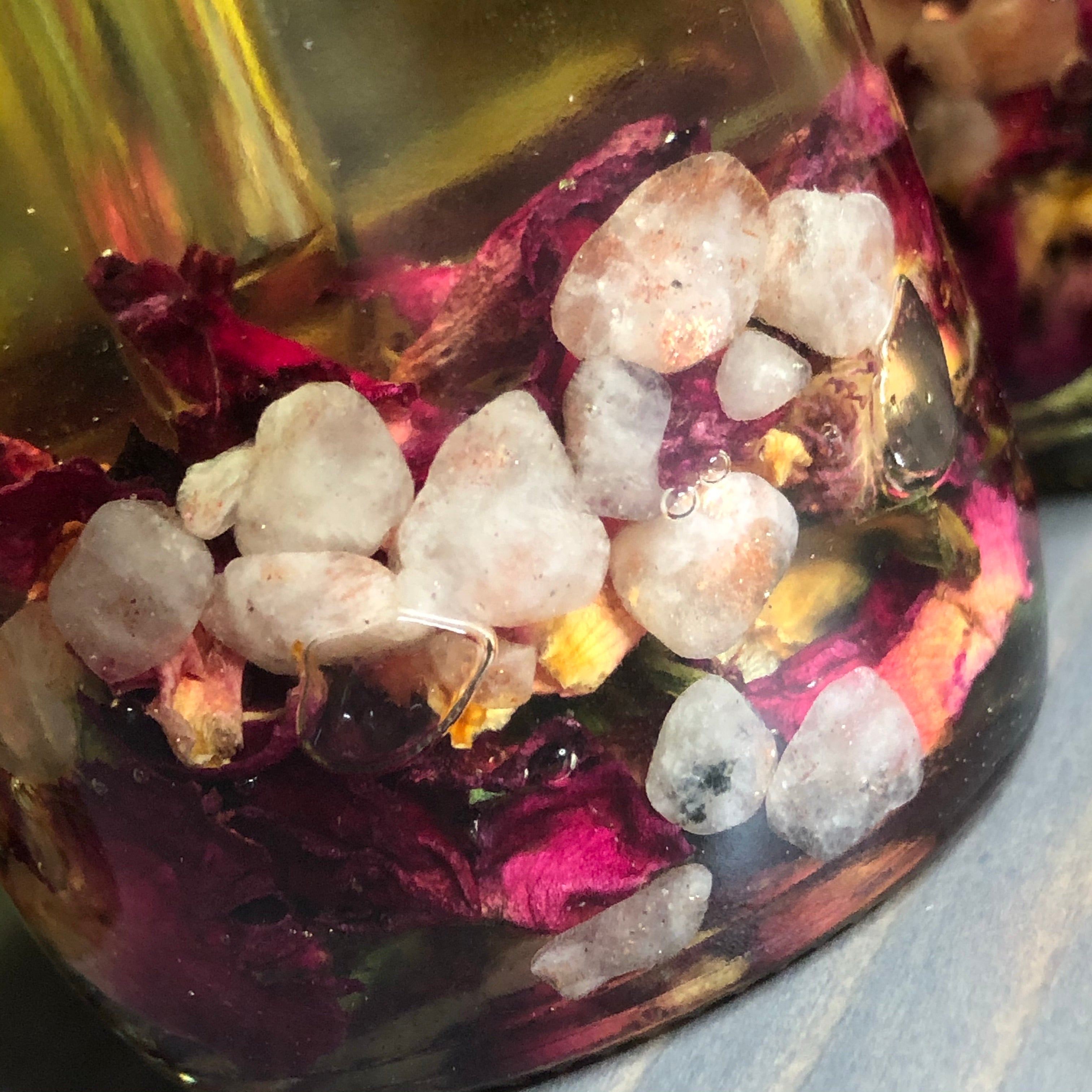 Crystal Irie Goddess Rose Body Oil bottle with rose petals and a soft background, showcasing the luxurious skincare product.