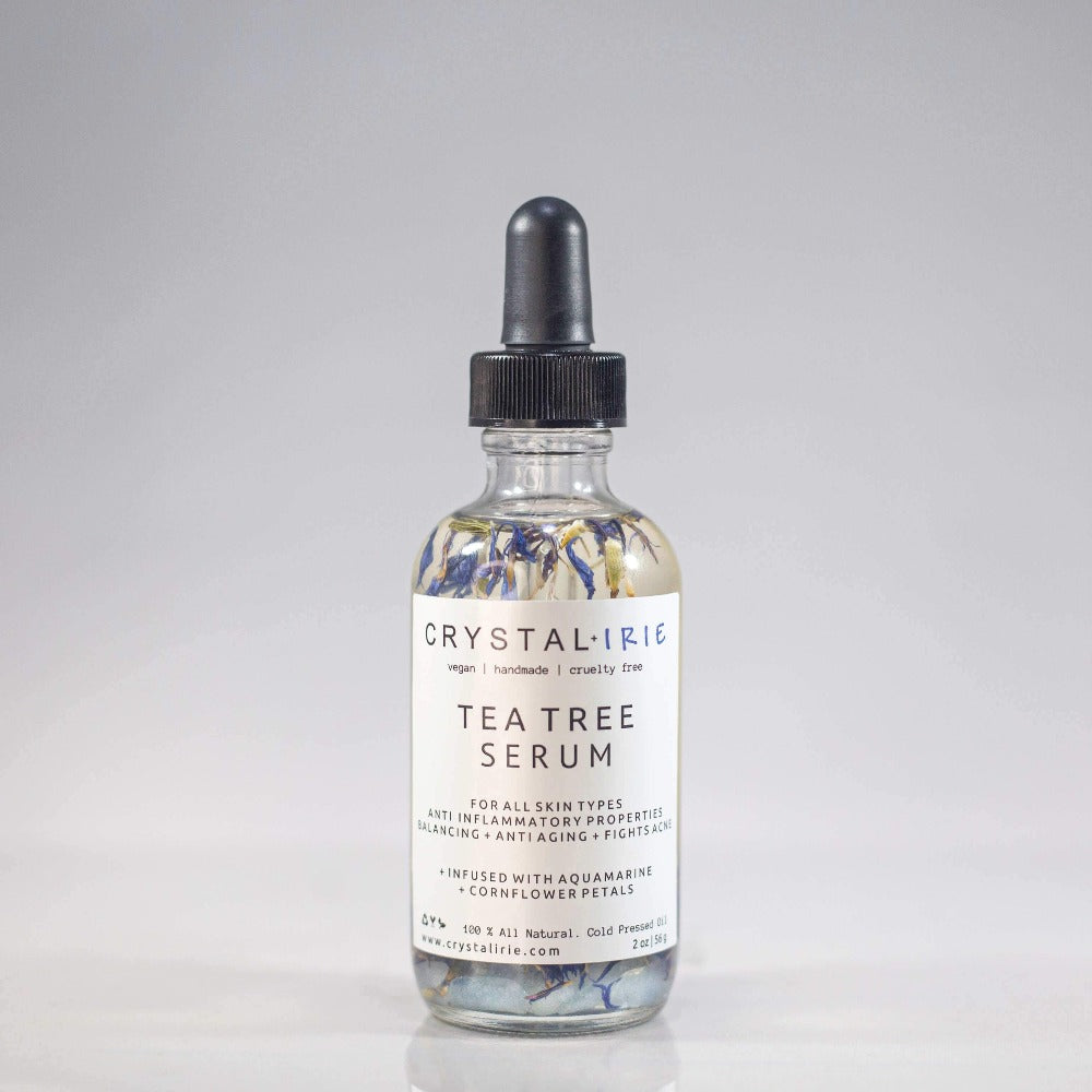 Crystal Irie Tea Tree Serum in a sleek bottle, showcasing the clear serum with tea tree leaves in the background.