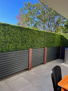 Dark green artificial boxwood hedge in planter boxes, UV resistant commercial grade hedge wall by Designer Plants USA.