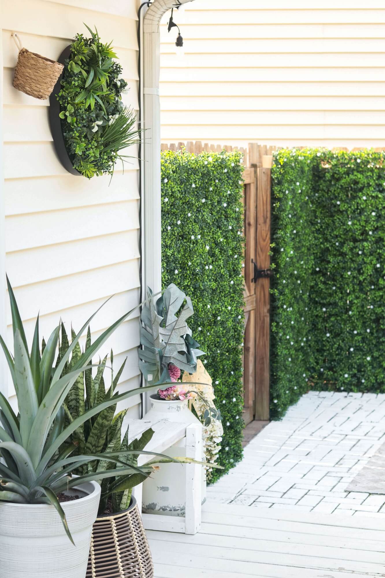 Artificial green wall disc with white frame, UV resistant, commercial grade, featuring lush flowering boxwood for living wall installations.