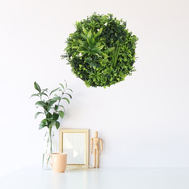 Artificial green wall disc with white frame and potted plants, UV resistant, commercial grade living wall by Designer Plants USA.