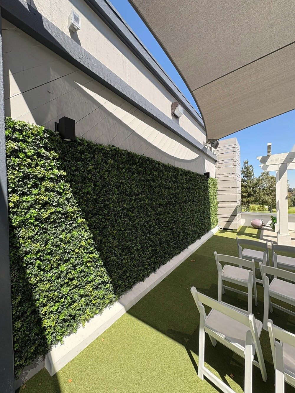 Outdoor vertical garden with dark boxwood artificial green wall panels, 6-piece set by Designer Plants USA, UV resistant for commercial use.