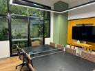Office boardroom with Designer Plants USA evergreen triptych artificial green wall panels, creating a lush, UV-resistant living wall.