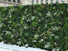 Artificial green wall panels from Designer Plants USA, featuring lush vertical garden with snow-like accents, UV resistant for outdoor use.