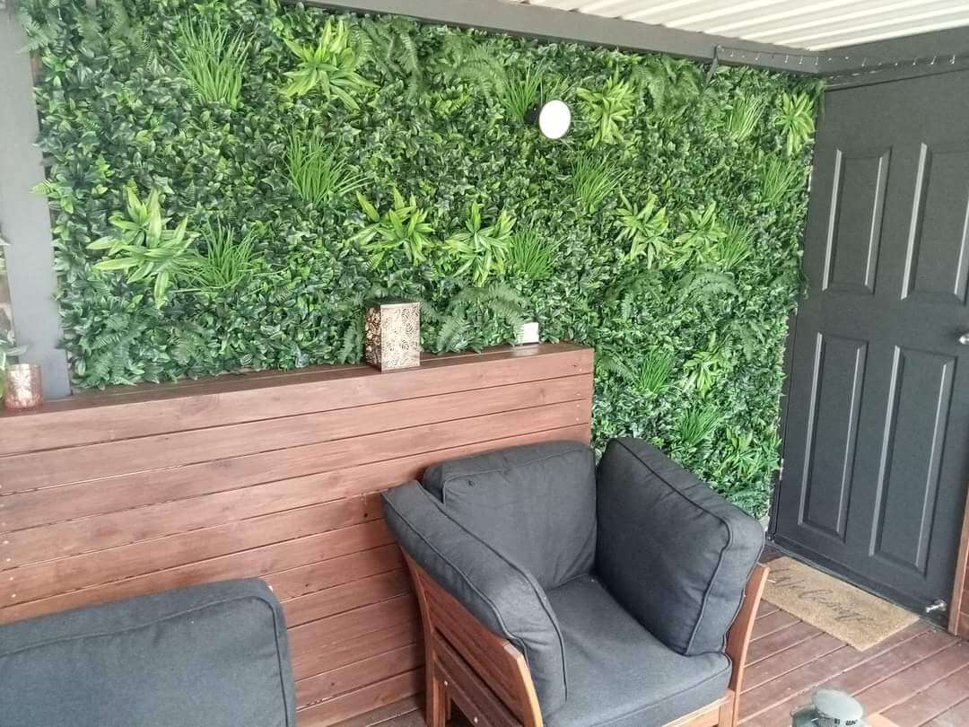 Artificial green wall panel with lush ferns from Designer Plants USA, UV resistant commercial-grade living wall for indoor or outdoor use.