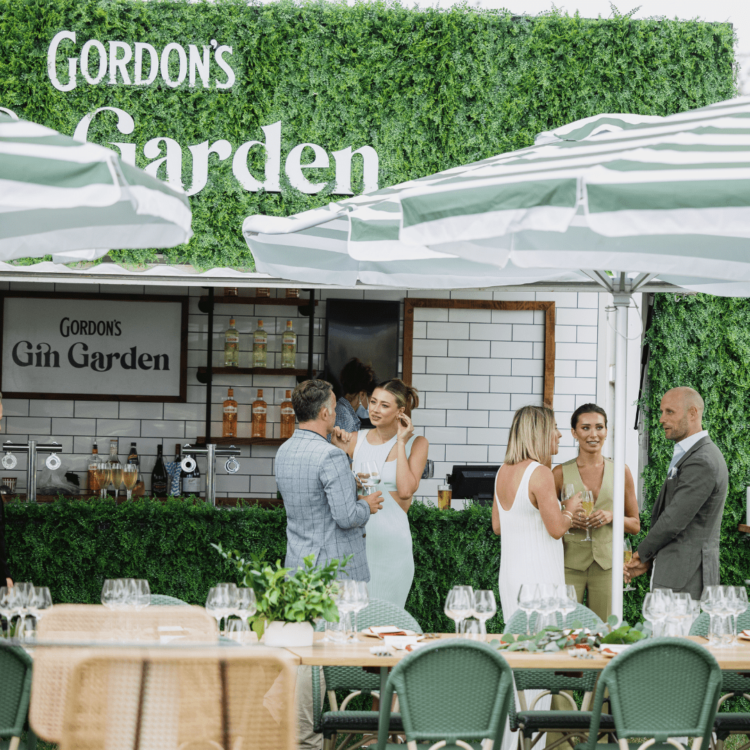 Event setup with lush green vertical garden wall panel by Designer Plants USA, UV resistant living wall for commercial or decorative use.