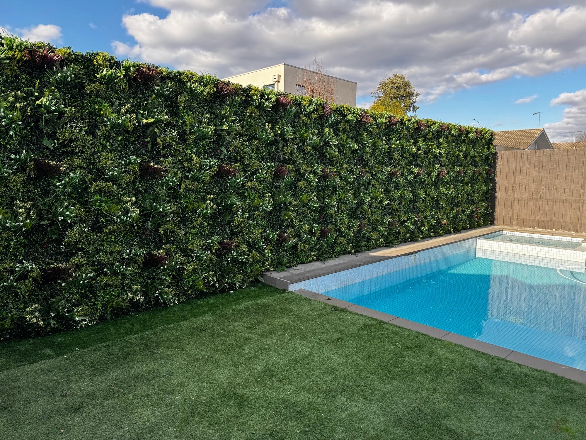 Artificial green wall panel by Designer Plants USA, lush spring-themed vertical garden for commercial or residential use.