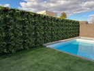 Artificial green wall panel by Designer Plants USA, lush spring-themed vertical garden for commercial or residential use.