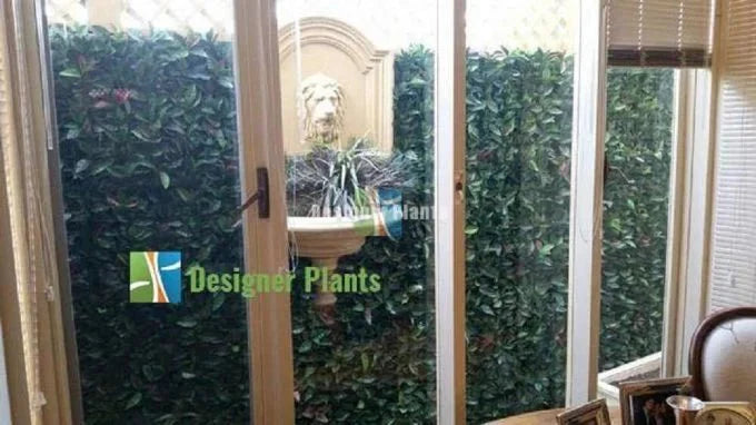 Photinia artificial vertical garden panel by Designer Plants USA, UV resistant living wall with lush green foliage, 40x40 inches.