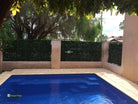 Photinia artificial vertical garden panel by Designer Plants USA, UV-resistant green wall with lush green foliage, 40x40 inches.