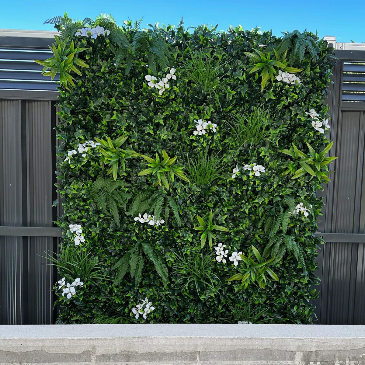 Snowy white artificial vertical garden wall panel by Designer Plants USA, UV resistant living wall for commercial or outdoor use.