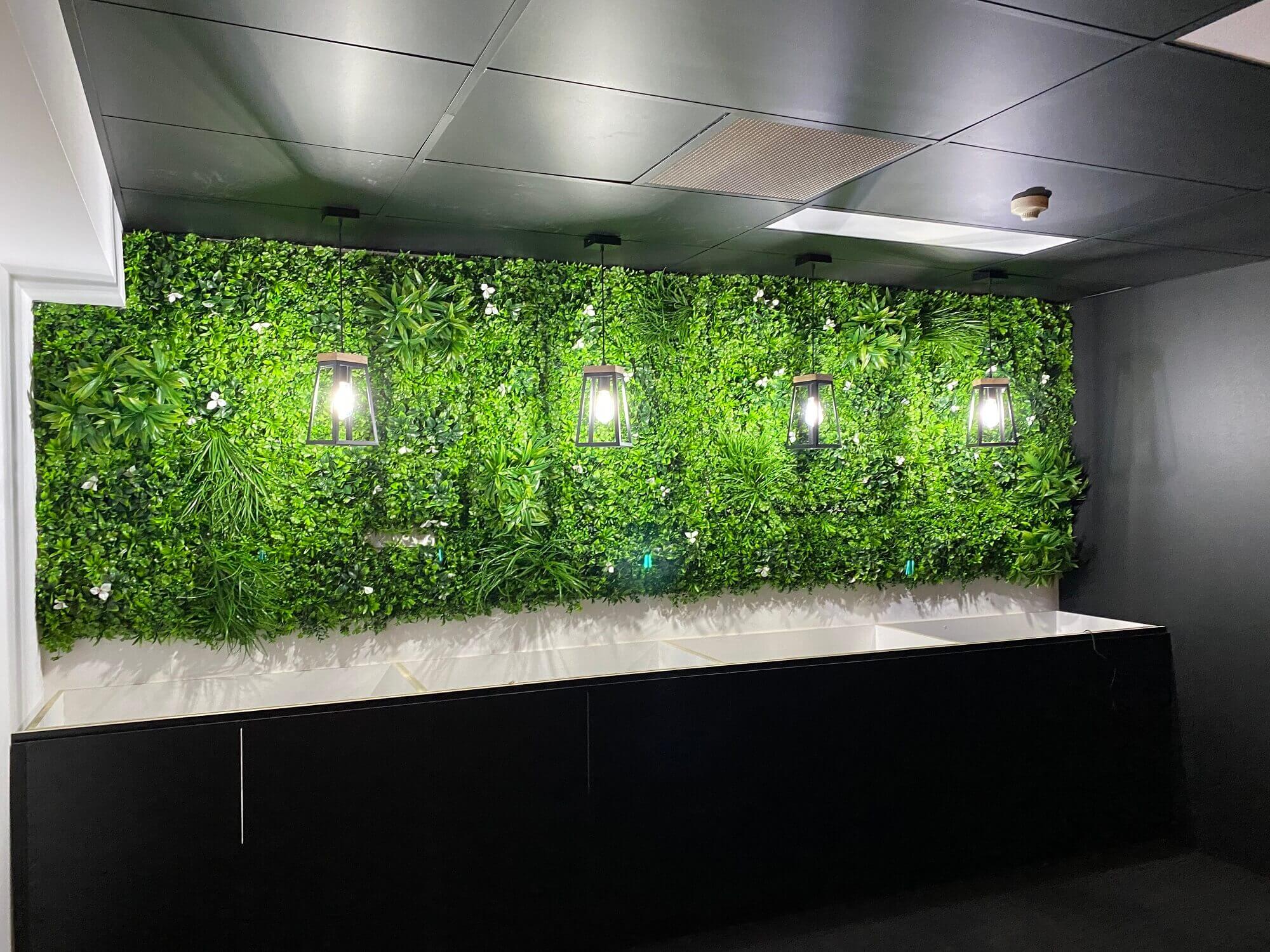 Artificial green wall panel with white flowers, UV resistant Designer Plants USA living wall for vertical garden or commercial spaces.