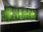 Artificial green wall panel with white flowers, UV resistant Designer Plants USA living wall for vertical garden or commercial spaces.