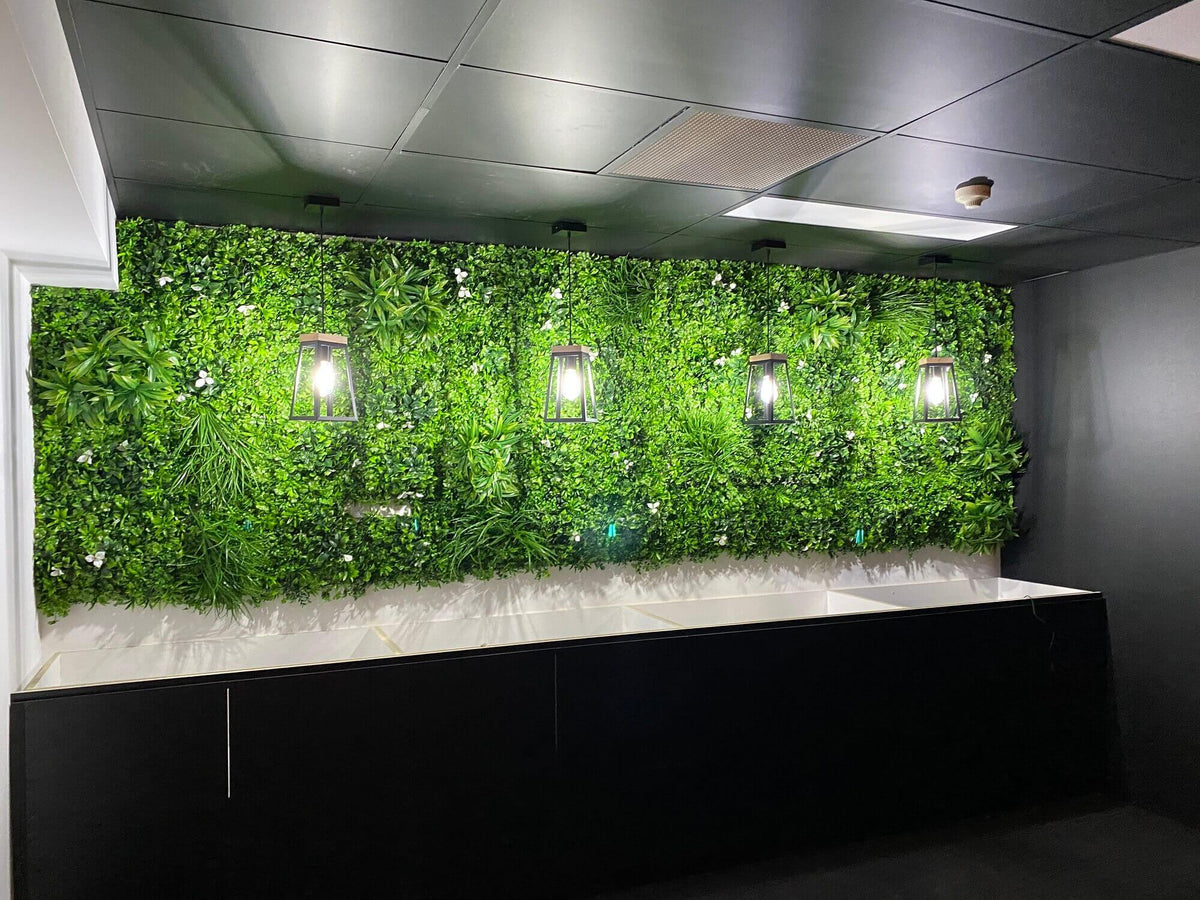 Artificial green wall panel with white flowers, UV resistant Designer Plants USA living wall for vertical garden or commercial spaces.