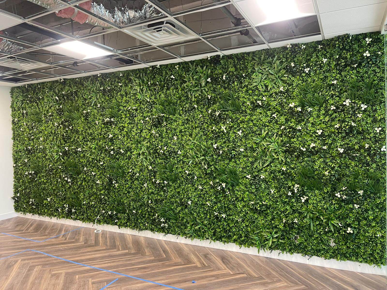 White Oasis artificial vertical garden panel installed in a Miami law office, showcasing a lush, UV-resistant living wall by Designer Plants USA.