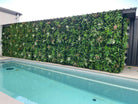 Artificial green wall panel by Designer Plants USA, 40x40 inch living wall with lush greenery, UV resistant for outdoor use along poolside.