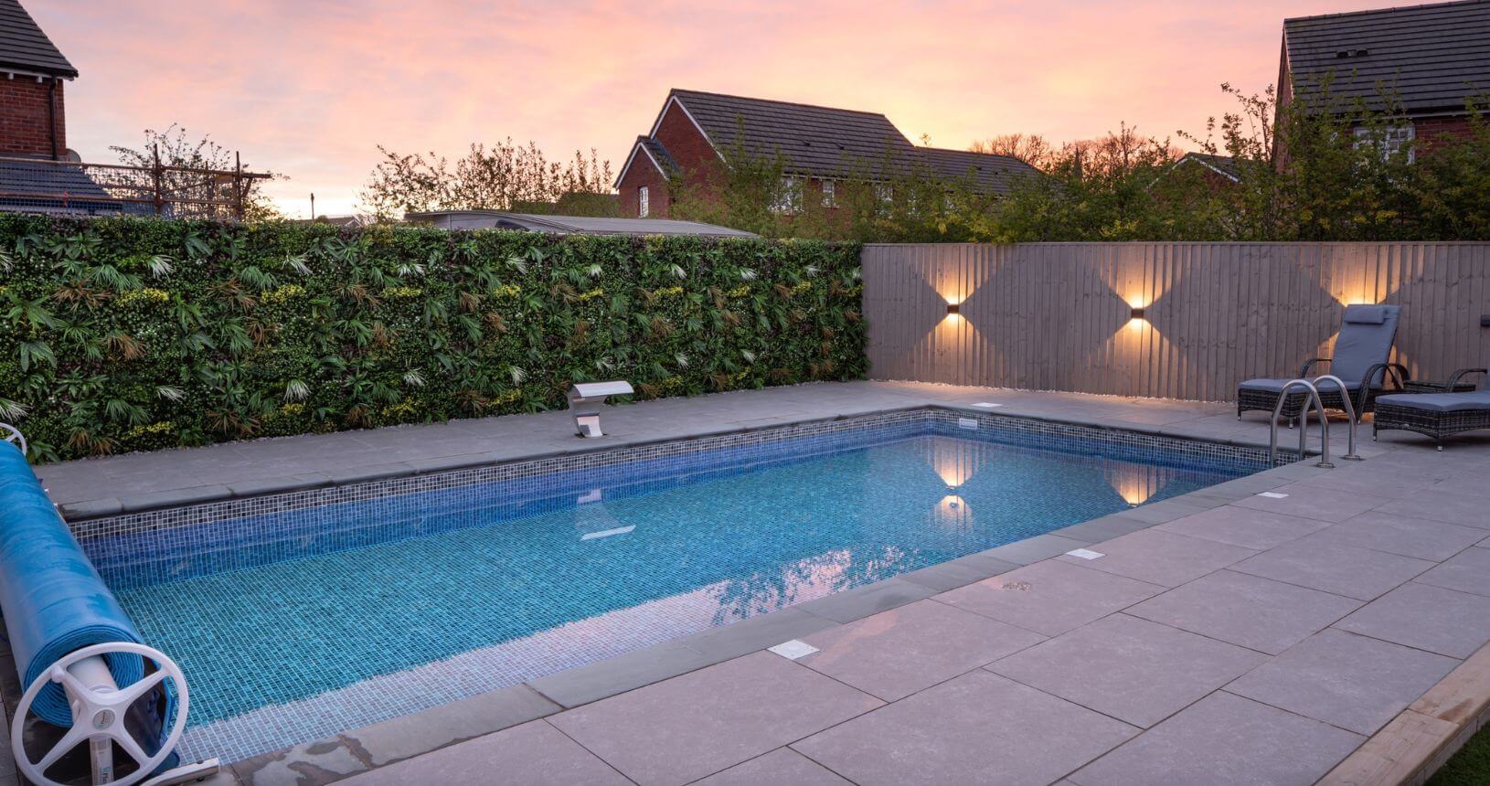 Wild Tropics artificial living wall panel by Designer Plants USA installed along a pool fence, UV resistant, 40x40 inch green wall for outdoor decor.