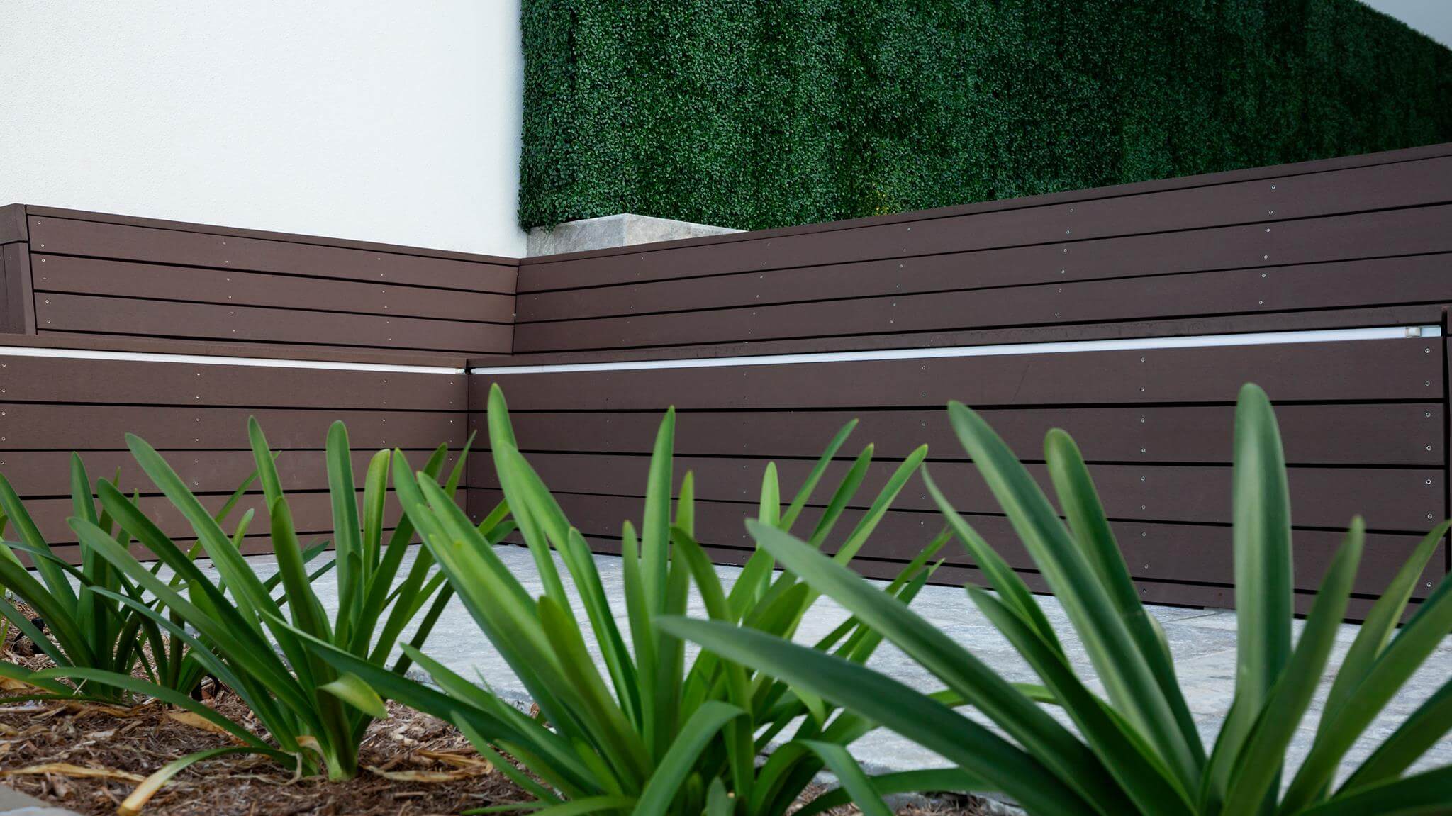 Small sample of Designer Plants USA dark boxwood green wall panel showing dense, lush faux greenery for interior or exterior decor.