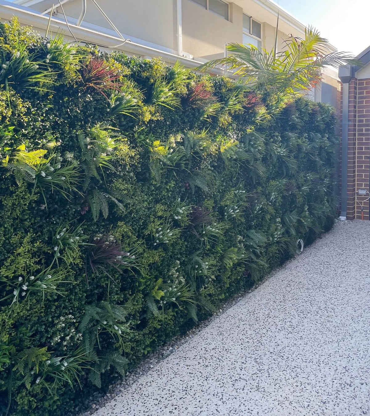 Small sample of Designer Plants USA lush spring vertical garden panel showing vibrant artificial green wall for fence decoration.