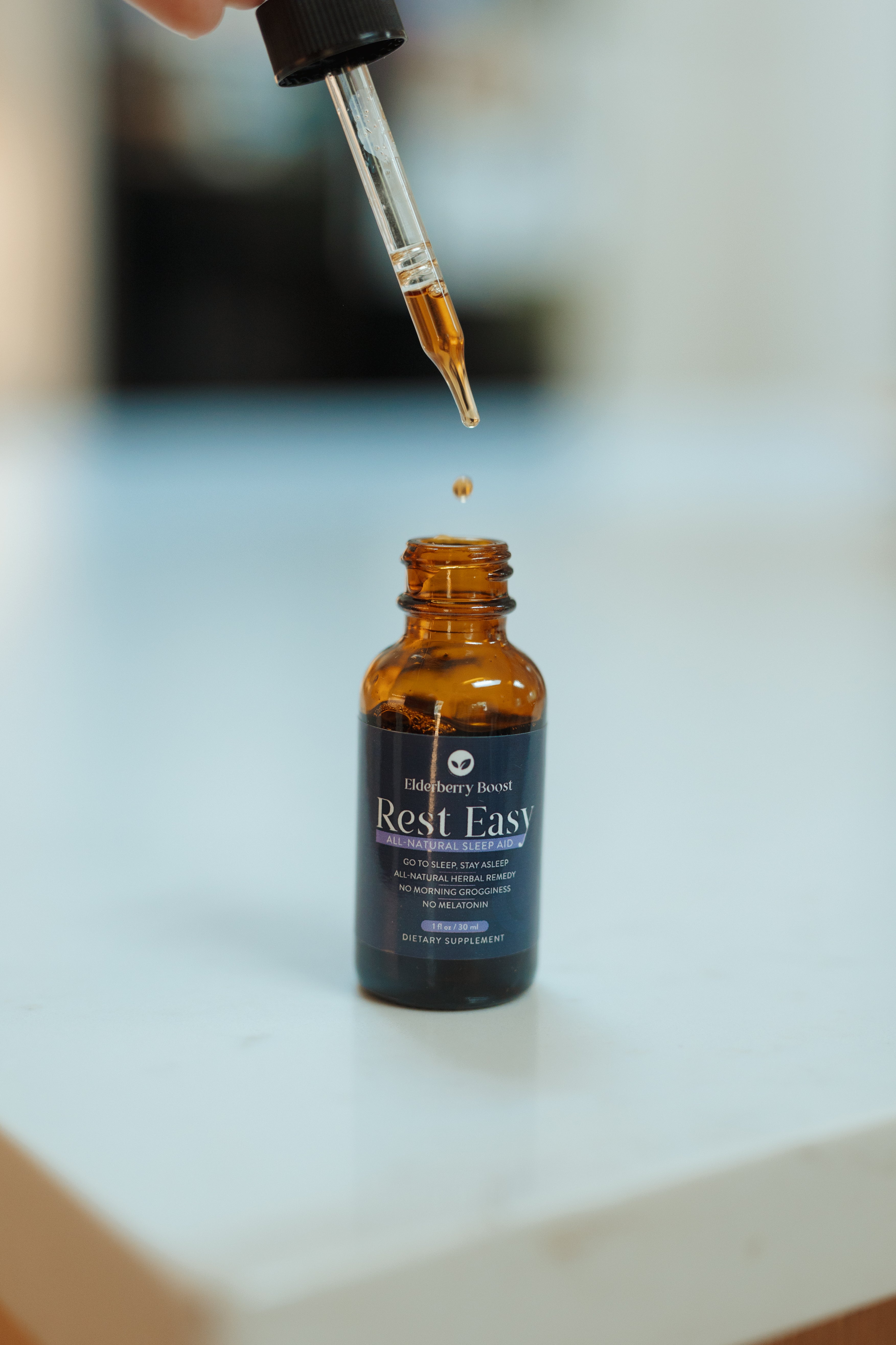All-natural Rest Easy sleep remedy tincture by Elderberry Boost, LLC, showing a dark glass bottle with a dropper for relaxation aid.