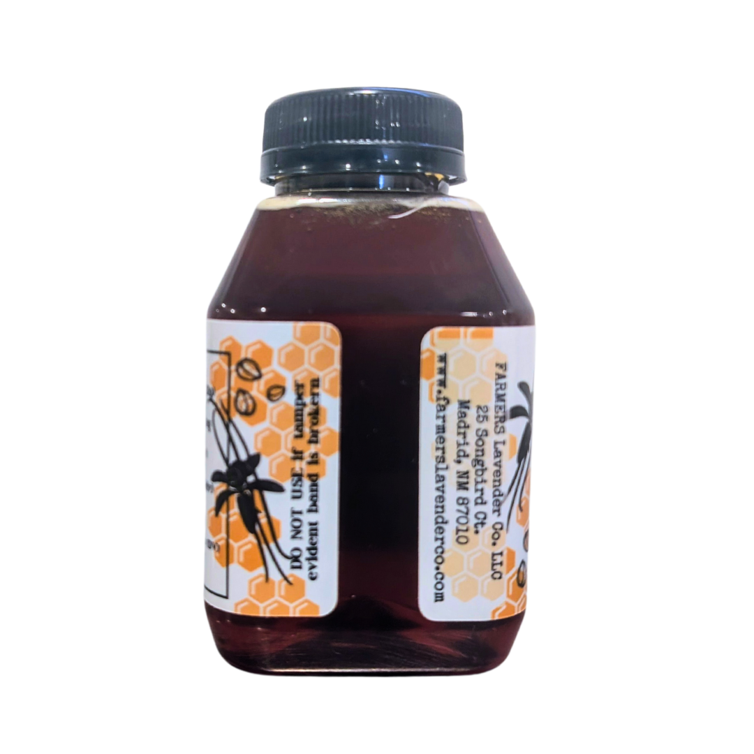 Glass jar of vanilla bean infused honey from FARMERS Lavender Co., showcasing smooth honey with vanilla bean pieces.