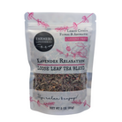Loose leaf Lavender Relaxation Tea blend by FARMERS Lavender Co. with dried lavender flowers and tea leaves in a clear glass jar.