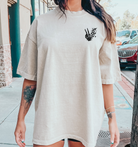 Front view of a graphic T-shirt titled "Busy Raising Feral Children" by Shop Karma Tees, featuring bold text design on a black shirt.