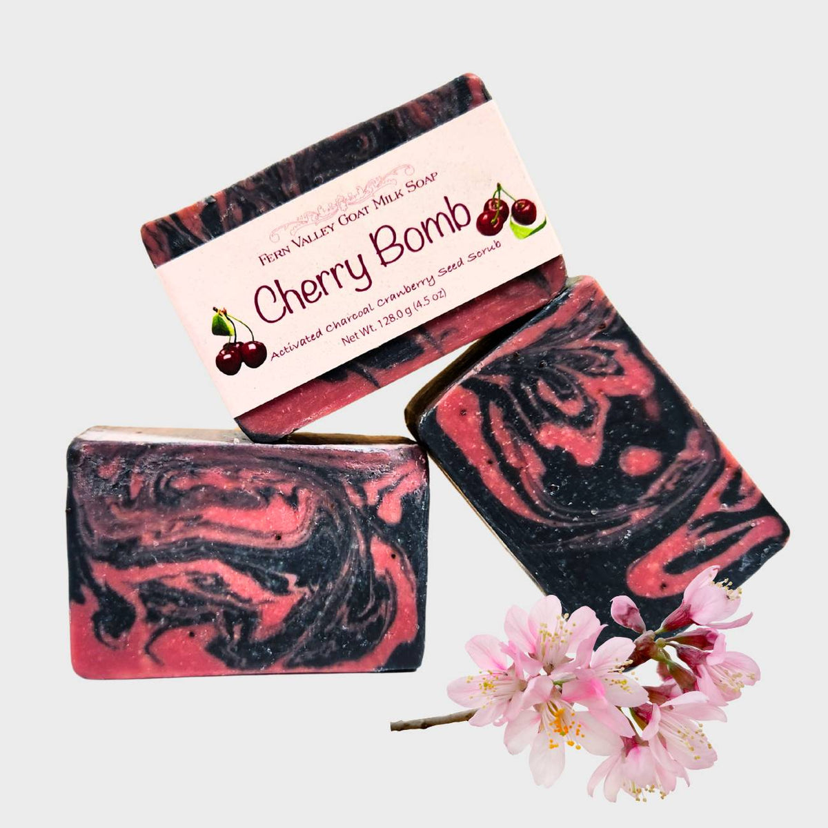 Fern Valley Goat Milk Soap with cherry scent featuring charcoal and cranberry seed scrub, showcasing a creamy soap bar with natural ingredients.