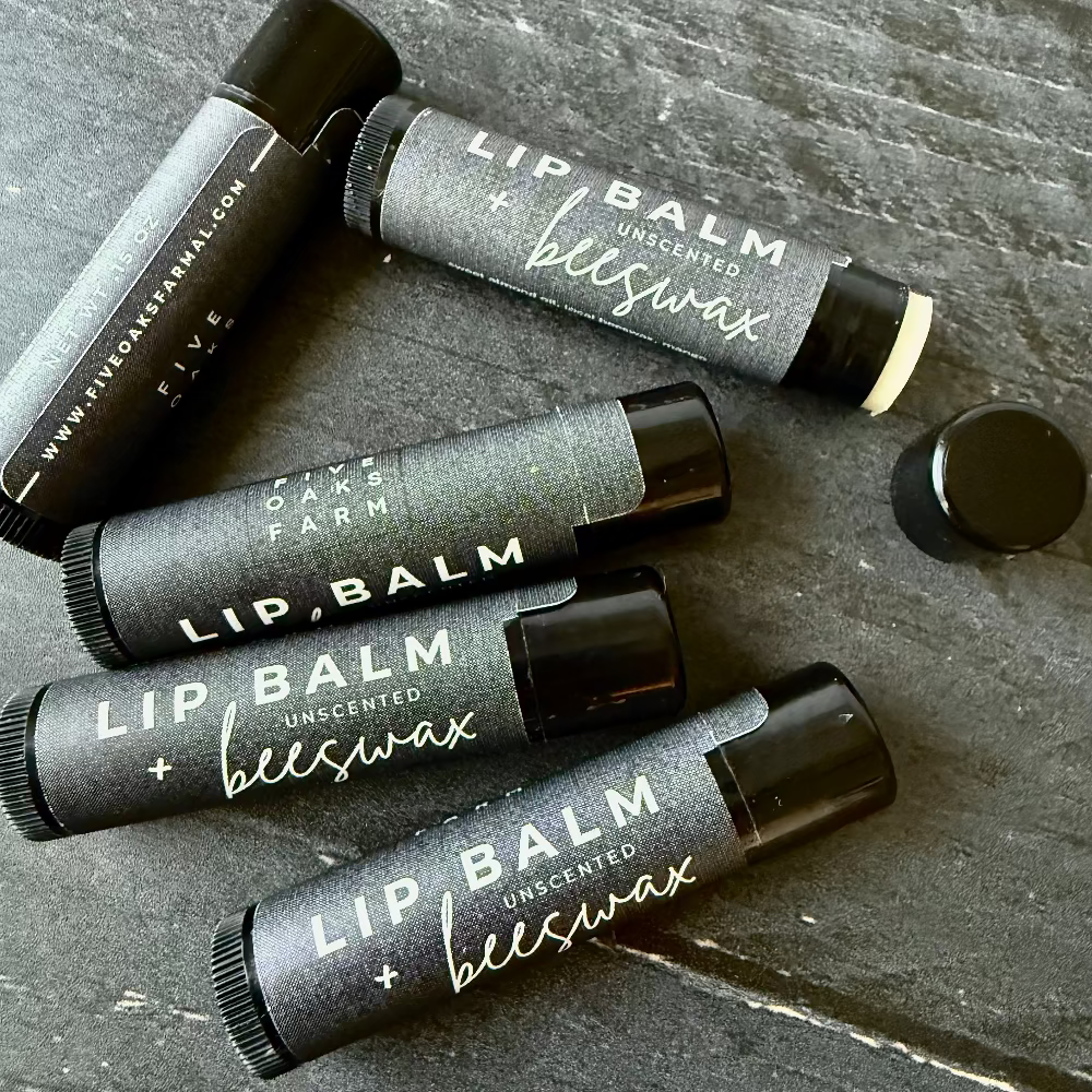 Unboxed Five Oaks Farm beeswax unscented lip balm in a small container, showing the natural, smooth wax formula.