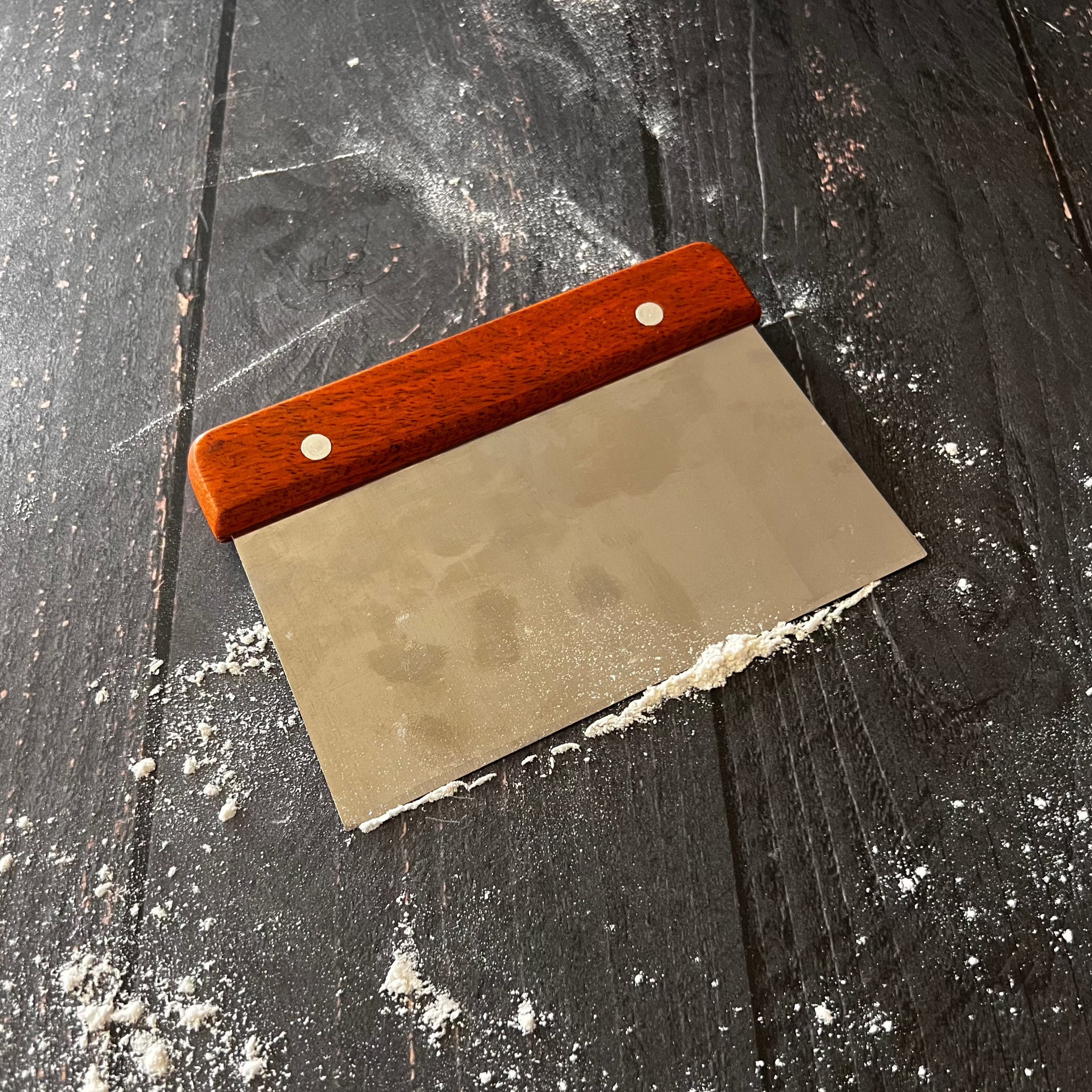 Five Oaks Farm bench scraper from the farm, with a sturdy handle and wide metal blade for kitchen and baking tasks.