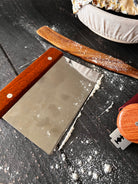 Farm-style bench scraper by Five Oaks Farm, featuring a sturdy handle and metal blade for kitchen and bakery use.