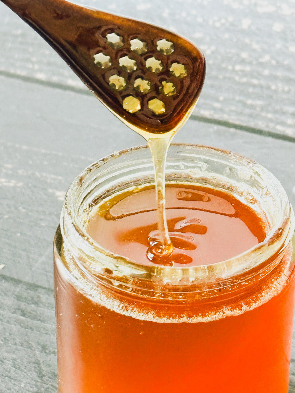 Five Oaks Farm honey spoon made from natural wood, designed for serving honey, with a smooth handle and rounded tip.