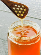 Five Oaks Farm honey spoon made from natural wood, designed for serving honey, with a smooth handle and rounded tip.