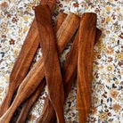 Rustic wooden Spurtle from Five Oaks Farm, showcasing its natural grain and handcrafted design for stirring and serving.