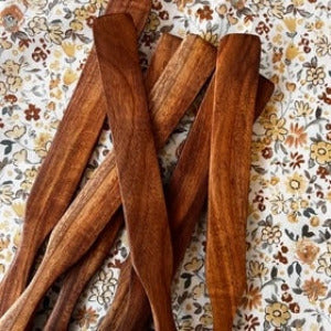 Rustic wooden Spurtle from Five Oaks Farm, showcasing its natural grain and handcrafted design for stirring and serving.