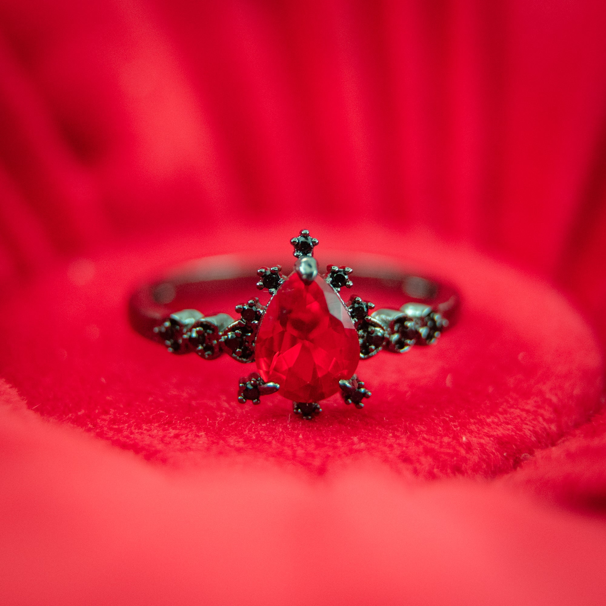 Fragrant Jewels Wicked Love bath bomb with a ring inside, floating in a bubbly bath with colorful fizz and aroma.