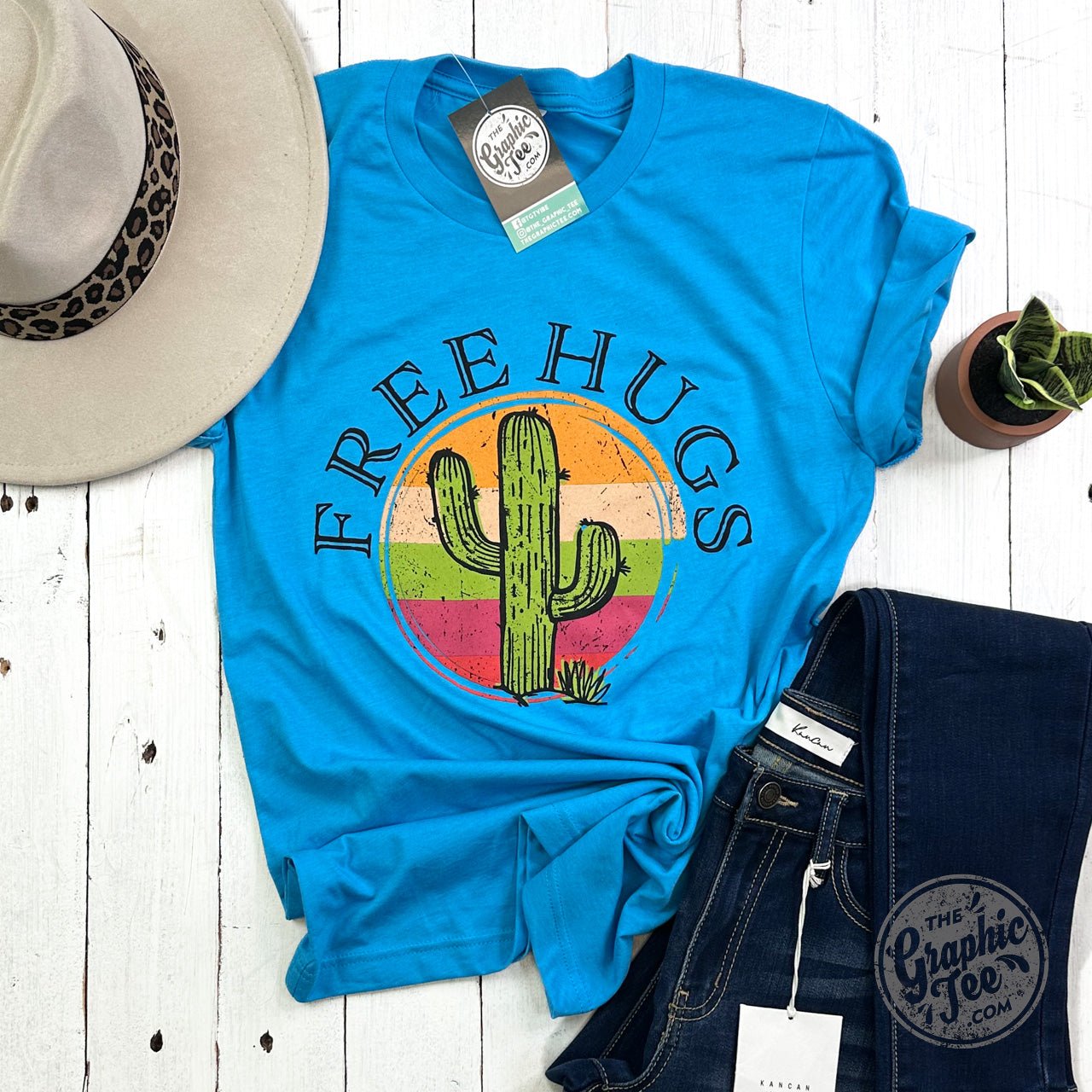 The Graphic Tee Free Hugs Cactus short sleeve crewneck graphic T-shirt featuring a playful cactus design on a white background.