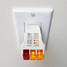 GroundLuxe outlet tester for grounding products showing a compact device with test indicator lights.