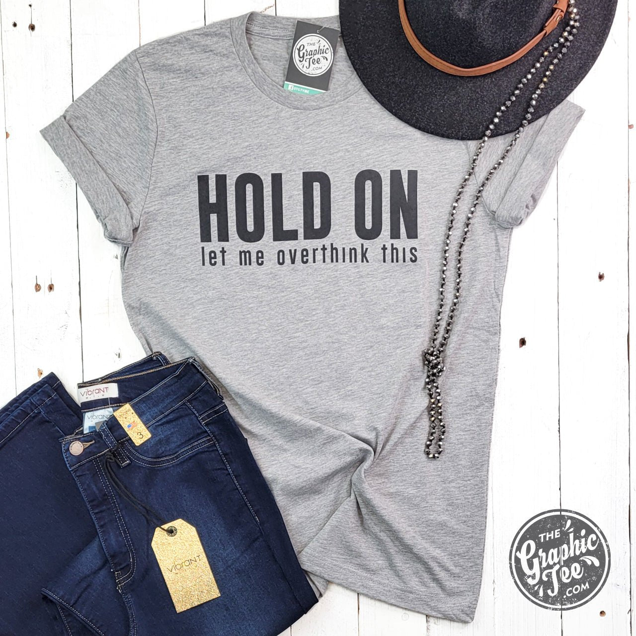 Unisex graphic T-shirt from The Graphic Tee with the phrase "Hold On Let Me Overthink This" printed on the front.