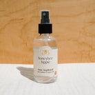 Face of Honeybee Hippie rose hydrosol bottle with spray nozzle, showcasing natural floral skincare product.